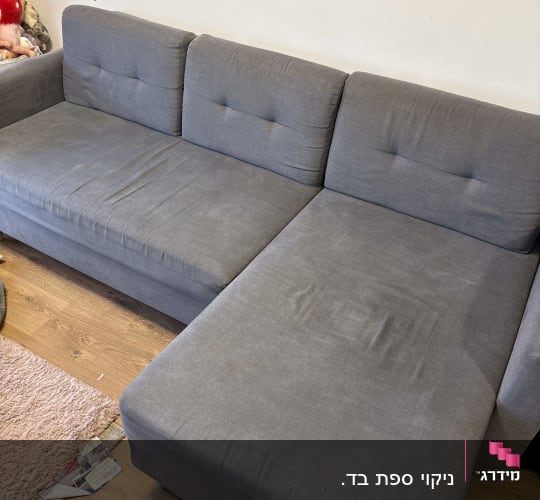 ספה אפורה נקייה על רצפת עץ